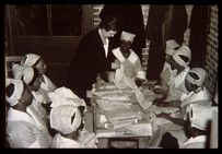 Large group of women working in with fabrics. Black and white photo.
